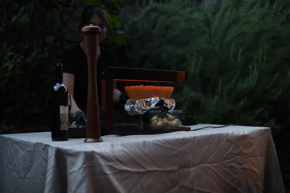 Poste de raclette installé en extérieur pour une soirée privée en Valais